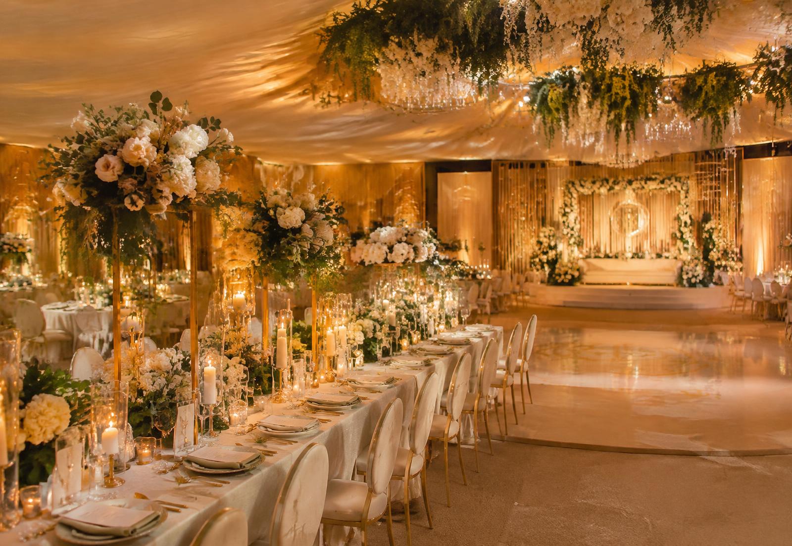 Candlelit wedding reception with ivory florals and gold chairs (sample image)